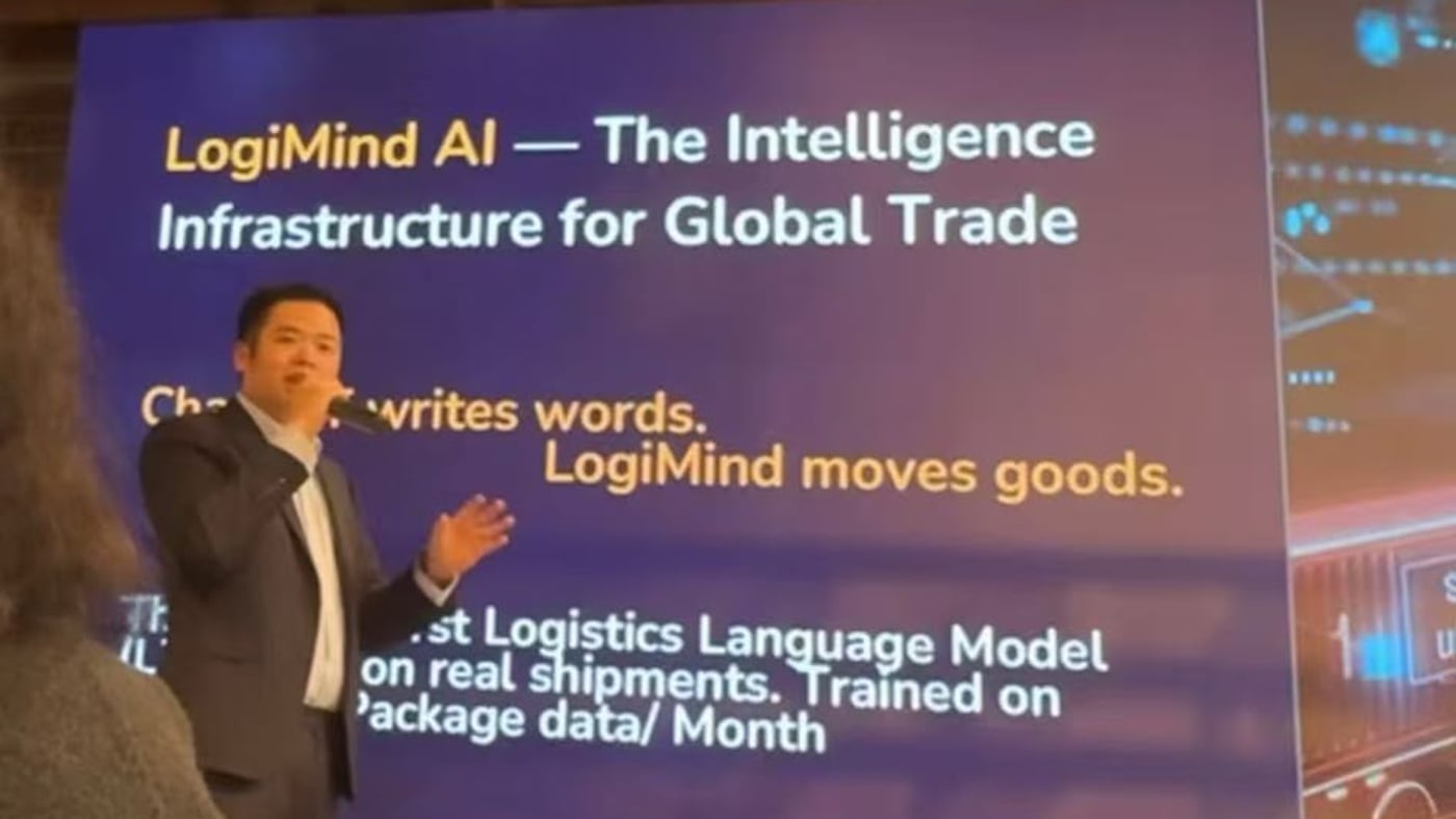A MashBond co-founder presenting LogiMind AI on stage at Silicon Valley Bank's Impact pitch during LA Tech Week — slide reads 'The Intelligence Infrastructure for Global Trade. ChatGPT writes words. LogiMind moves goods.'